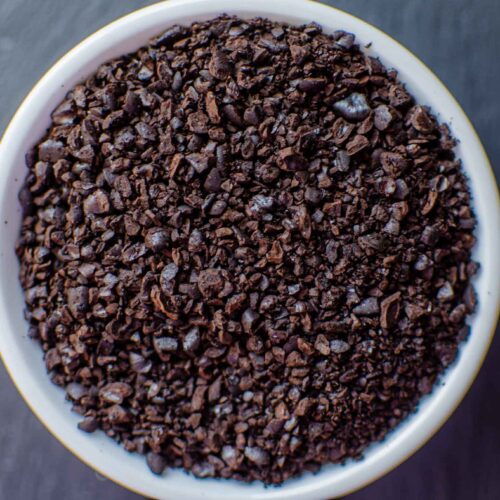 Coarse ground coffee beans in white dish