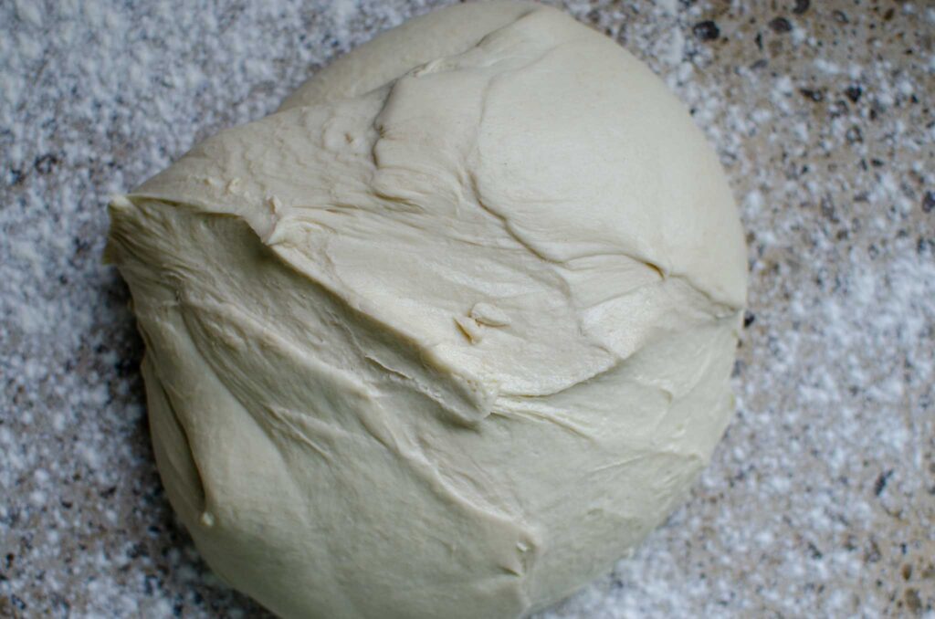 Sourdough pizza dough after bulk ferment on lightly dusted work surface