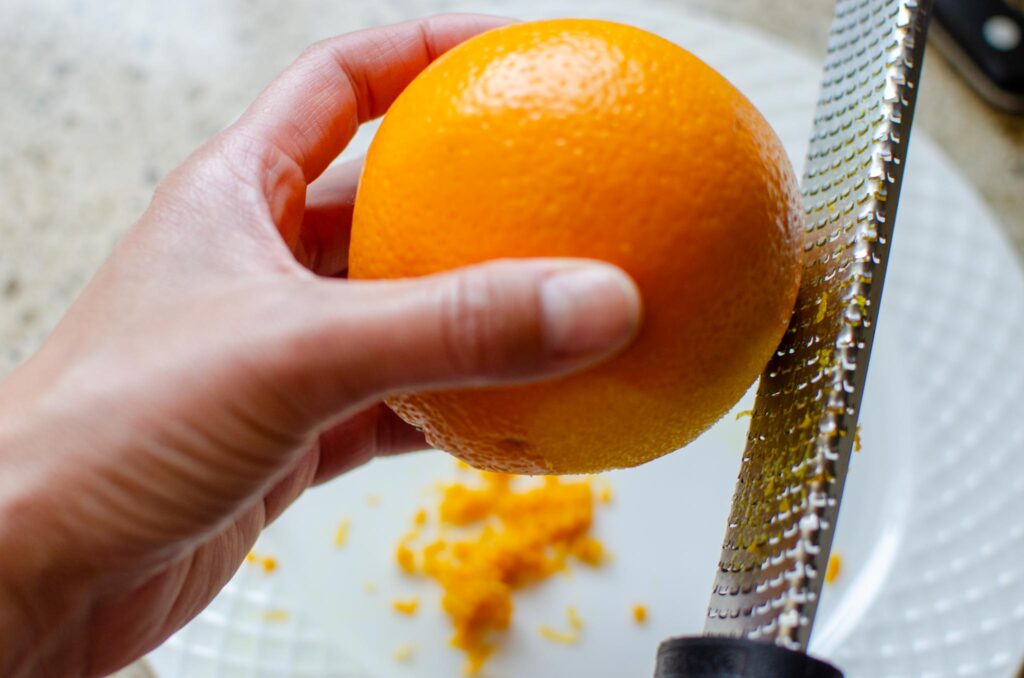 zesting an orange with a citrus zester