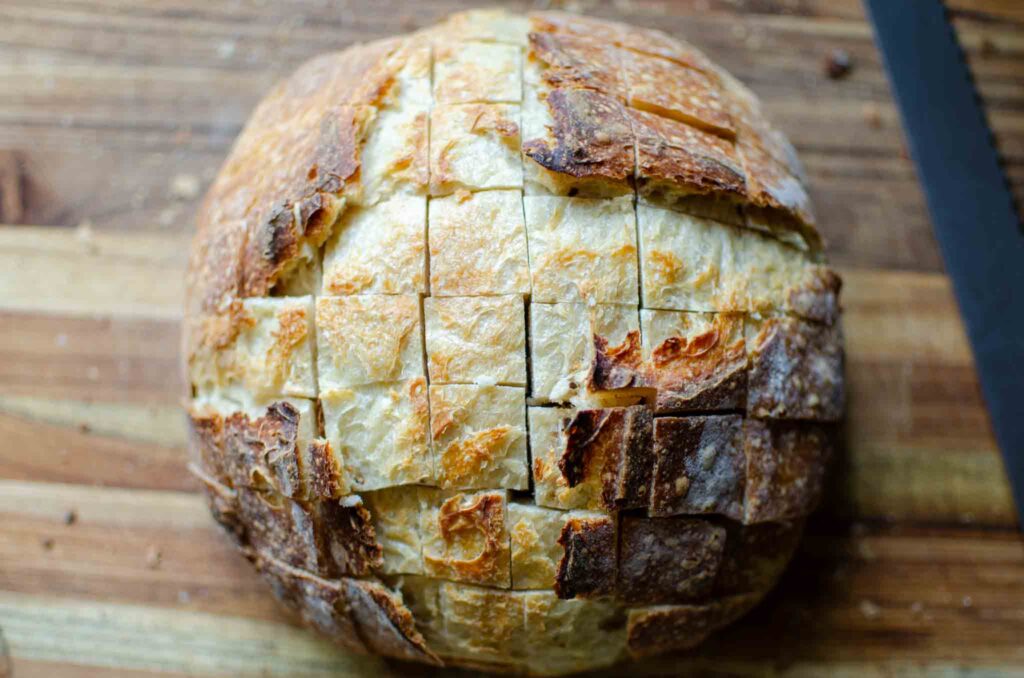 all of the cuts complete in a loaf a loaf of easy sourdough cheese and garlic pull apart bread