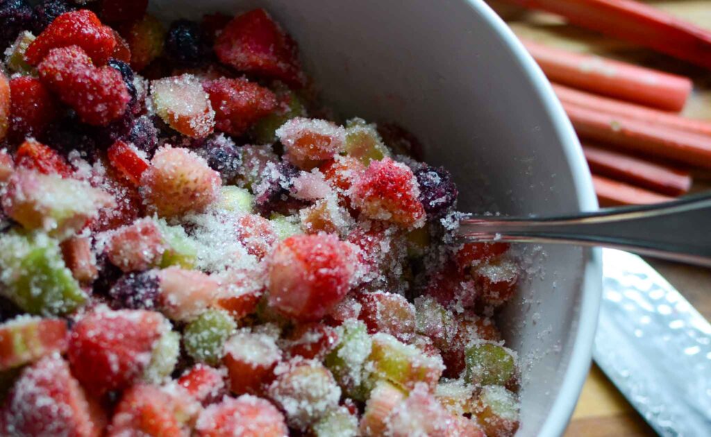 Fruit combined with sugar in white bowl