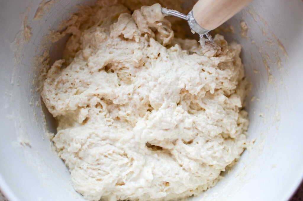 Sourdough cinnamon roll focaccia dough mixed with a Danish dough whisk