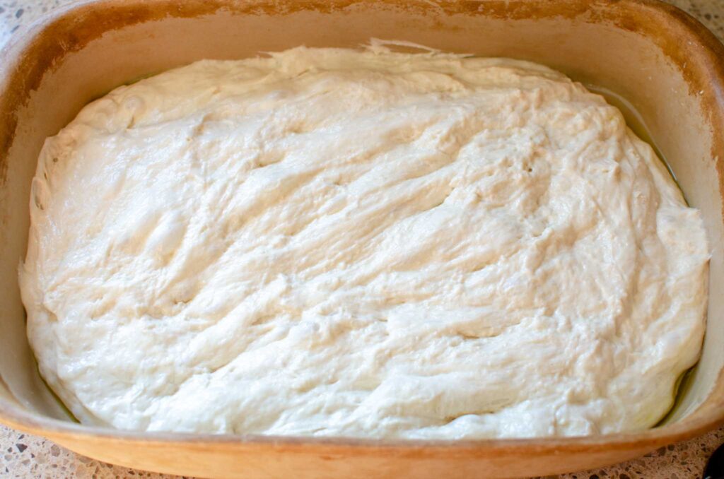 sourdough cinnamon roll focaccia dough in baking dish