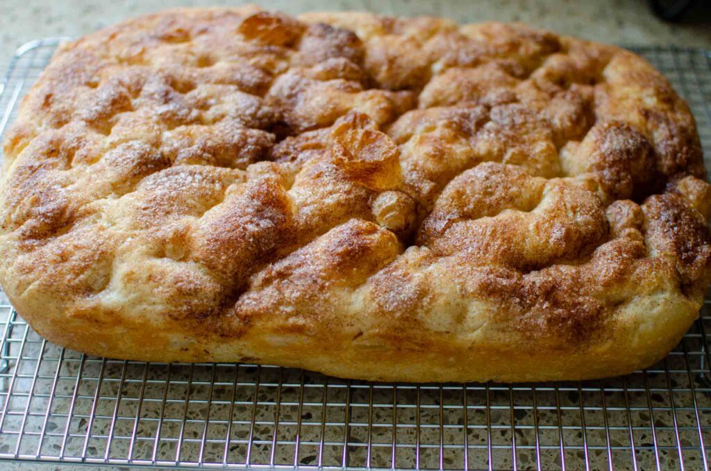 sourdough cinnamon roll focaccia cooling on wire rack