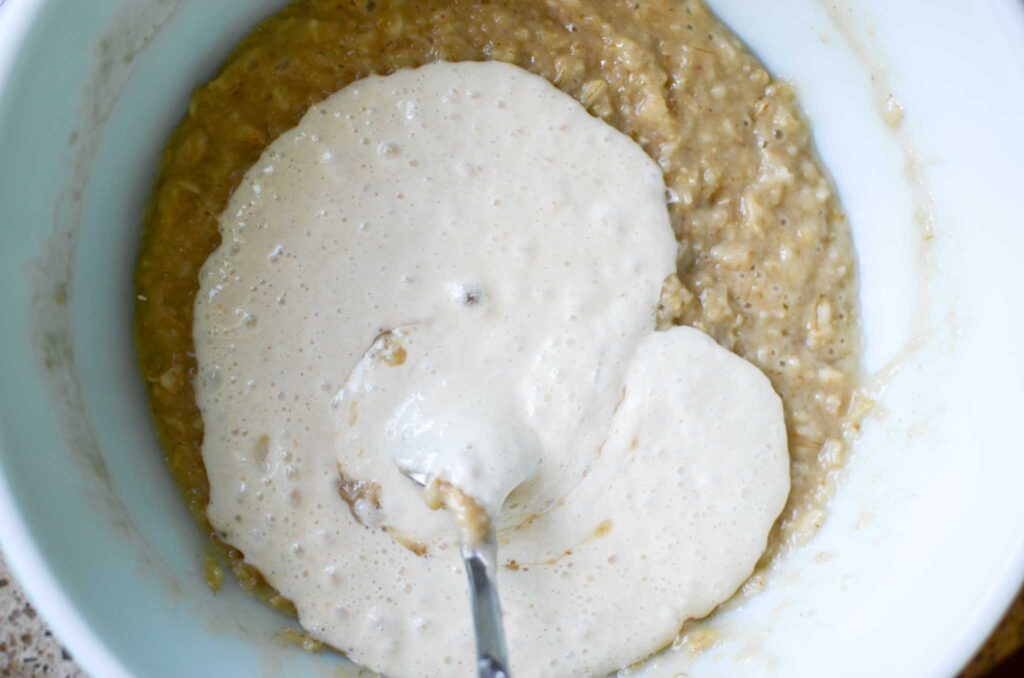 adding sourdough starter to oatmeal mixture for oatmeal dinner rolls