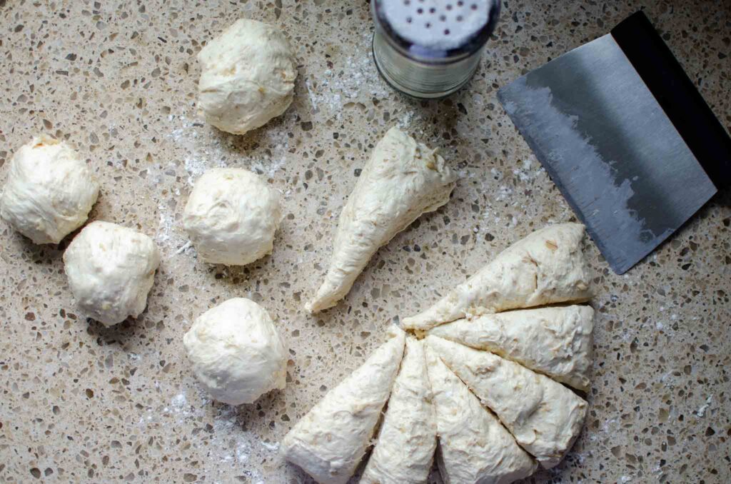 shaping sourdough oatmeal dinner rolls dough into dough balls