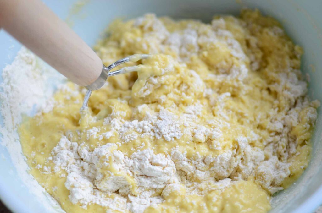 mixing in dry ingredients into the wet using a Danish dough whisk