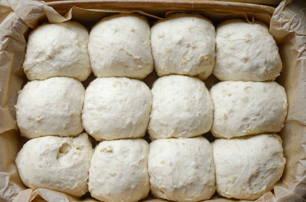 oatmeal dinner rolls dough balls in parchment lined pan after second rise