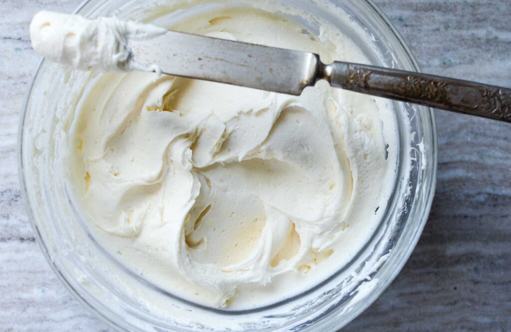  frosting in glass bowl with some on knife 