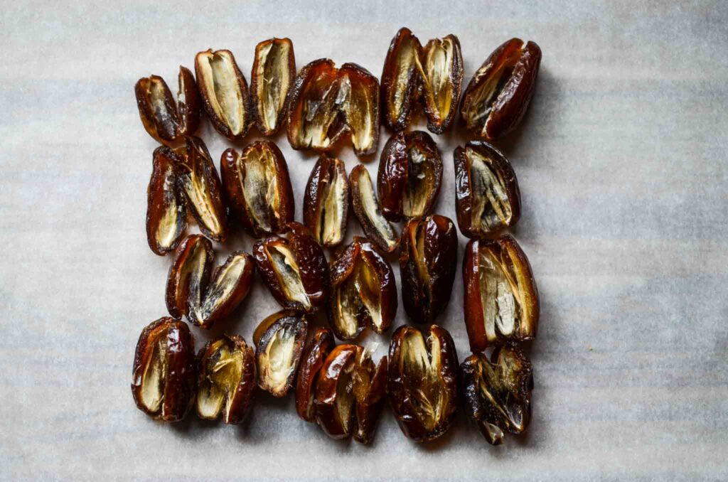 pitted dates arranged on parchment paper