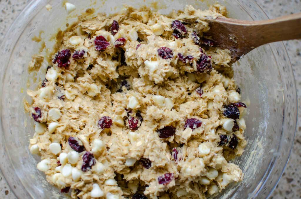 sourdough white chocolate cranberry oatmeal cookie dough in a glass bowl