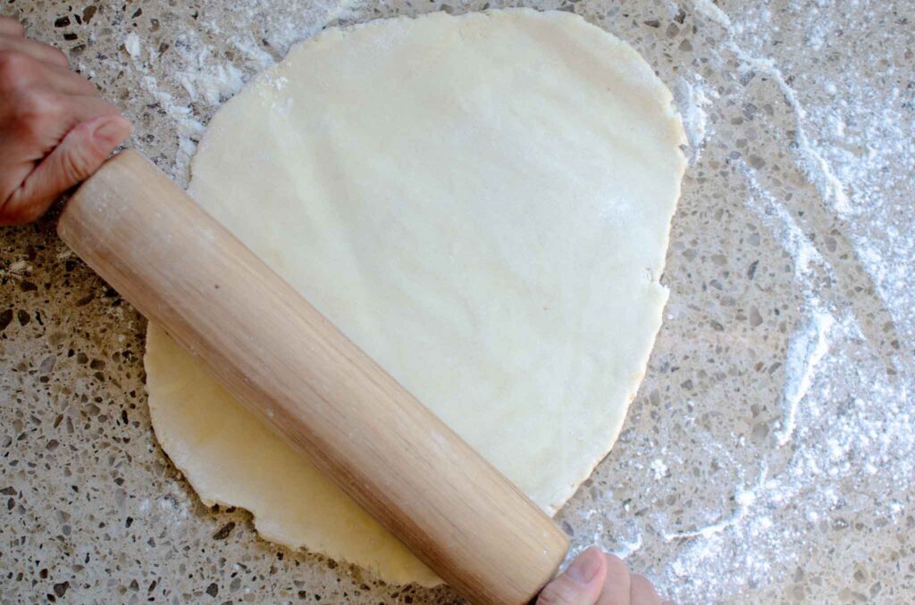 Rolling out sourdough pie crust with rolling pin