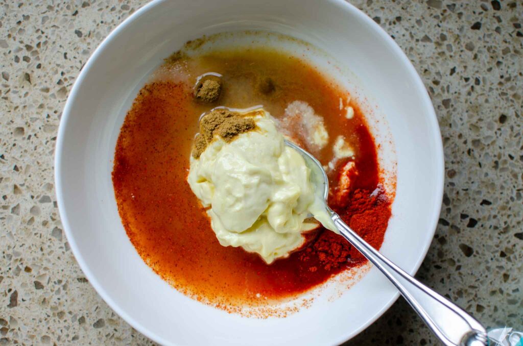 adding spices to bowl of mayo and lime juice