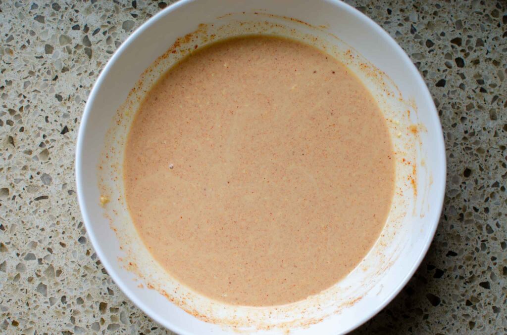 a white bowl of creamy citrus dressing