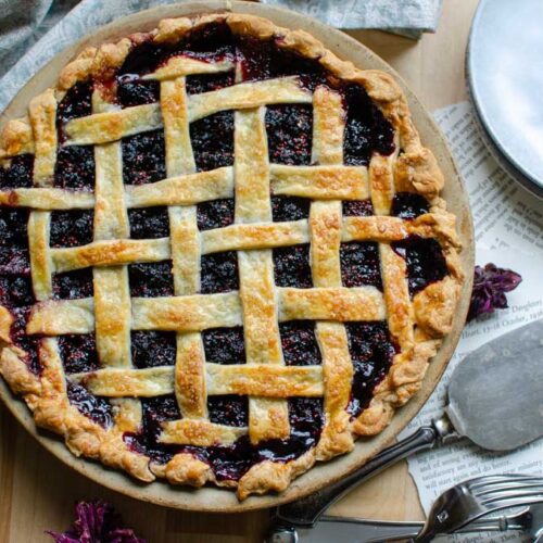 mulberry pie with lattice top with pie scoop and small plate