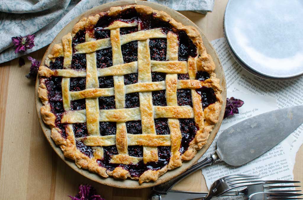 mulberry pie with lattice top with pie scoop and small plate