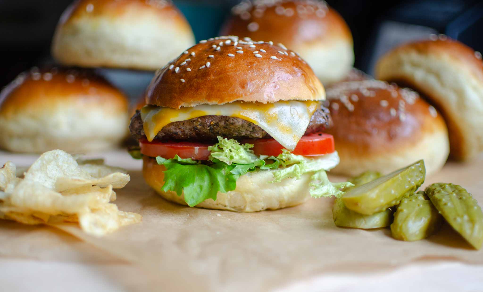 homemade 1 hour hamburger buns with a burger, chips, and pickles