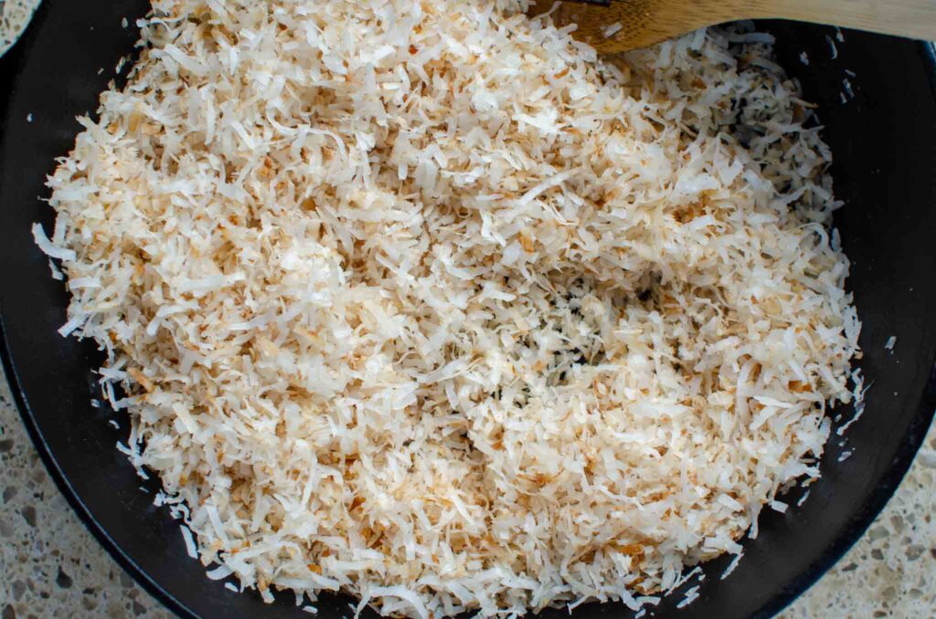 toasting shredded coconut in a cast iron pan