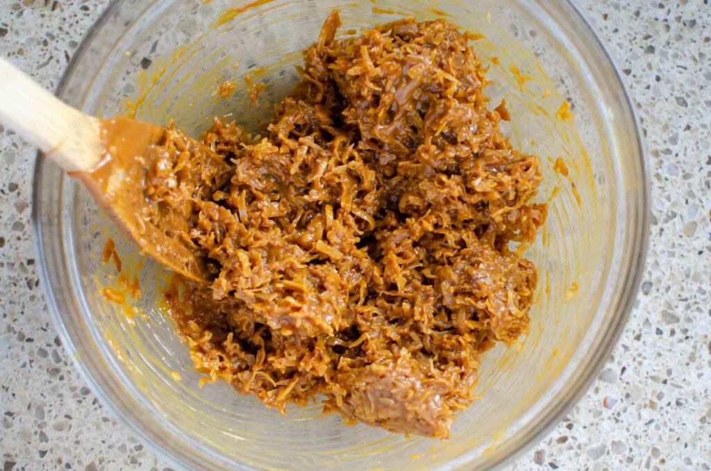 dulce de leche mixed with shredded coconut in glass bowl