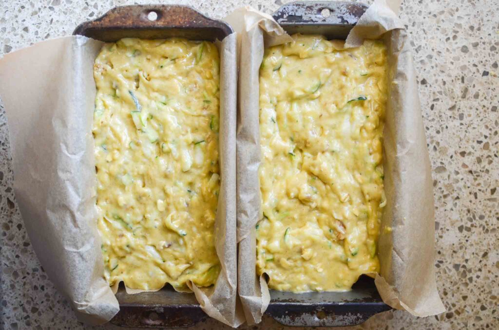 sourdough zucchini batter in parchment lined metal loaf pan