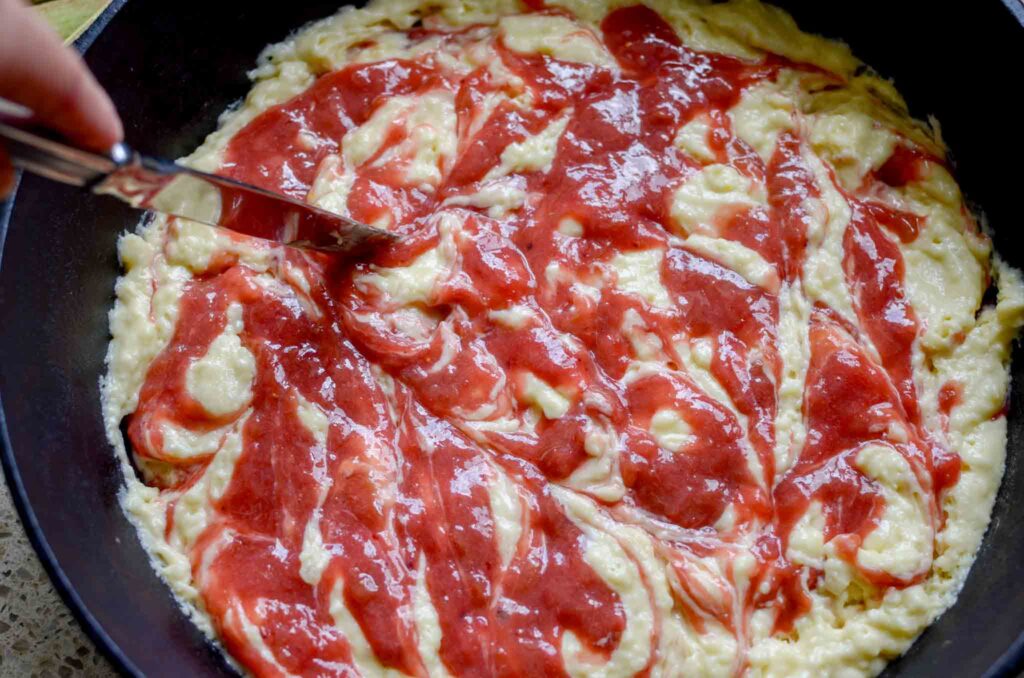 Swirling the compote into the rhubarb spoon cake batter with a butter knife