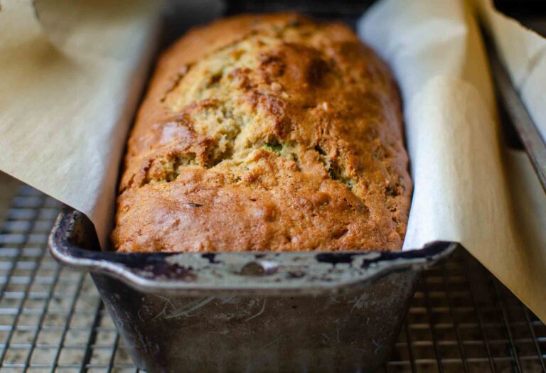 sourdough zucchini bread in parchment paper lined metal loaf pan