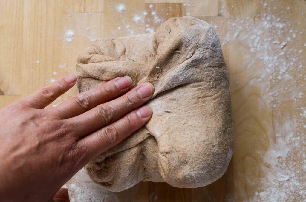 folding the sides of the dough inward to meet in the middle