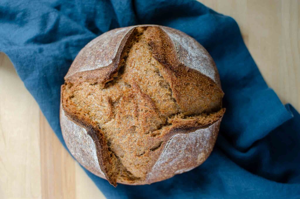 100% whole wheat sourdough bread loaf on blue napkin