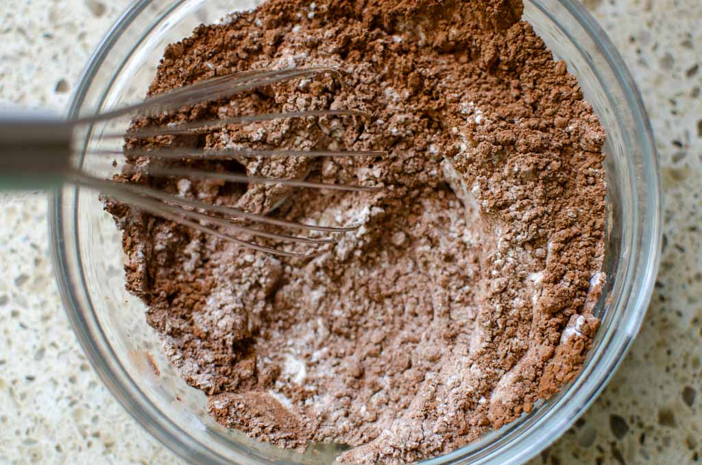 mixed dry ingredients in a glass bowl for sourdough chocolate zucchini bread