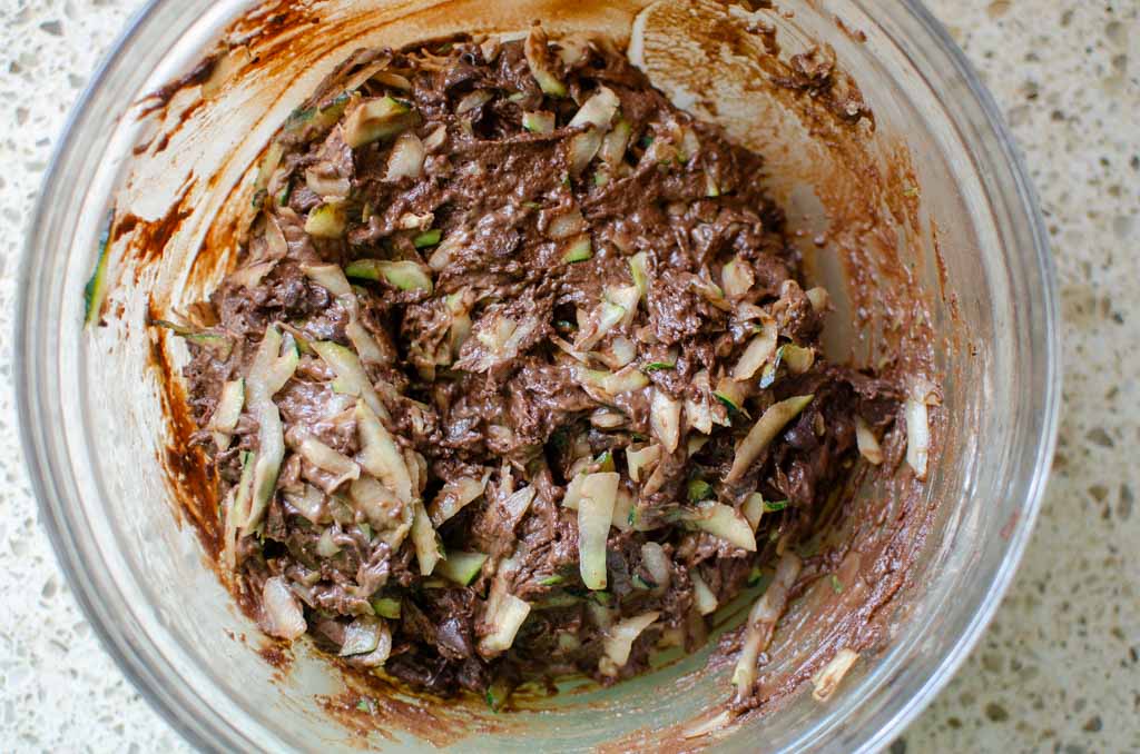 sourdough chocolate zucchini bread batter with grated zucchini and chocolate chips stirred in