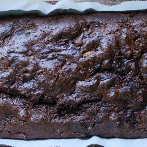 Sourdough chocolate zucchini bread loaf in parchment paper lined loaf pan