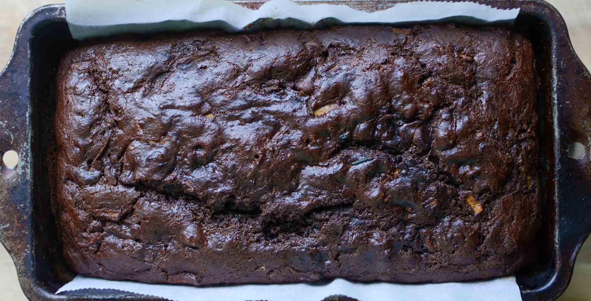 Sourdough chocolate zucchini bread loaf in parchment paper lined loaf pan