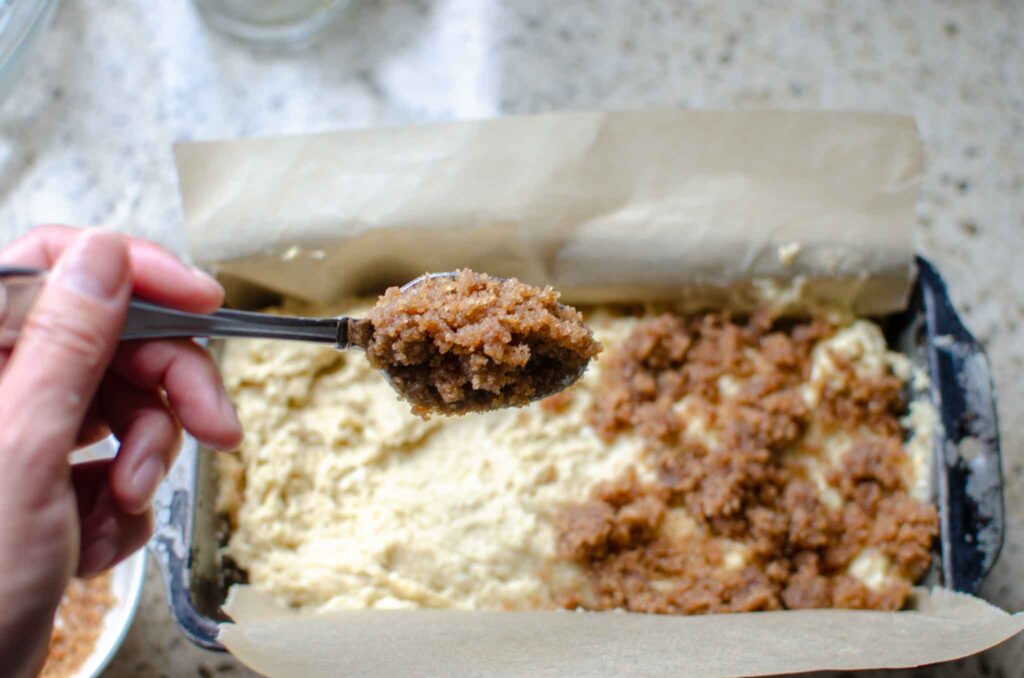 spooning cinnamon sugar mixture over batter