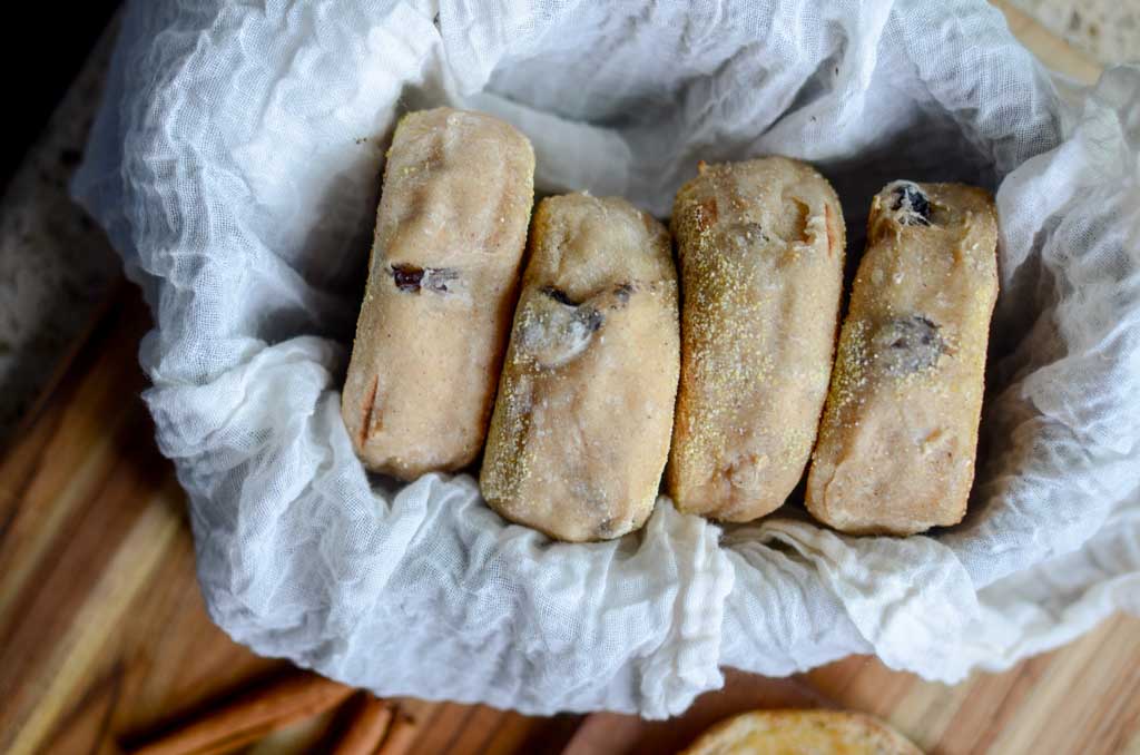 Sourdough cinnamon raisin English muffins in a cloth lined basket