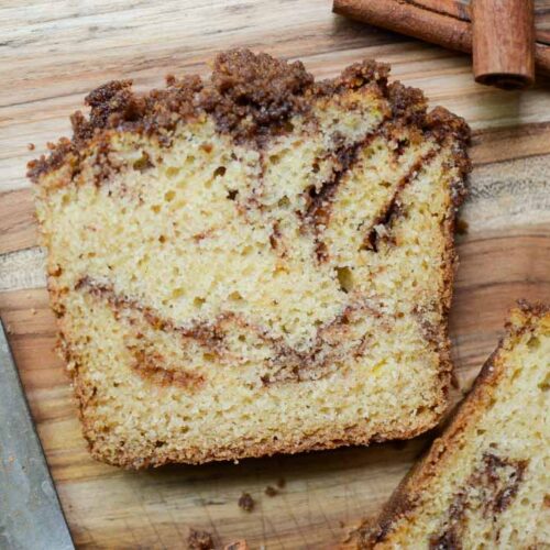 a slice of sourdough cinnamon sugar quick bread on wood cutting board