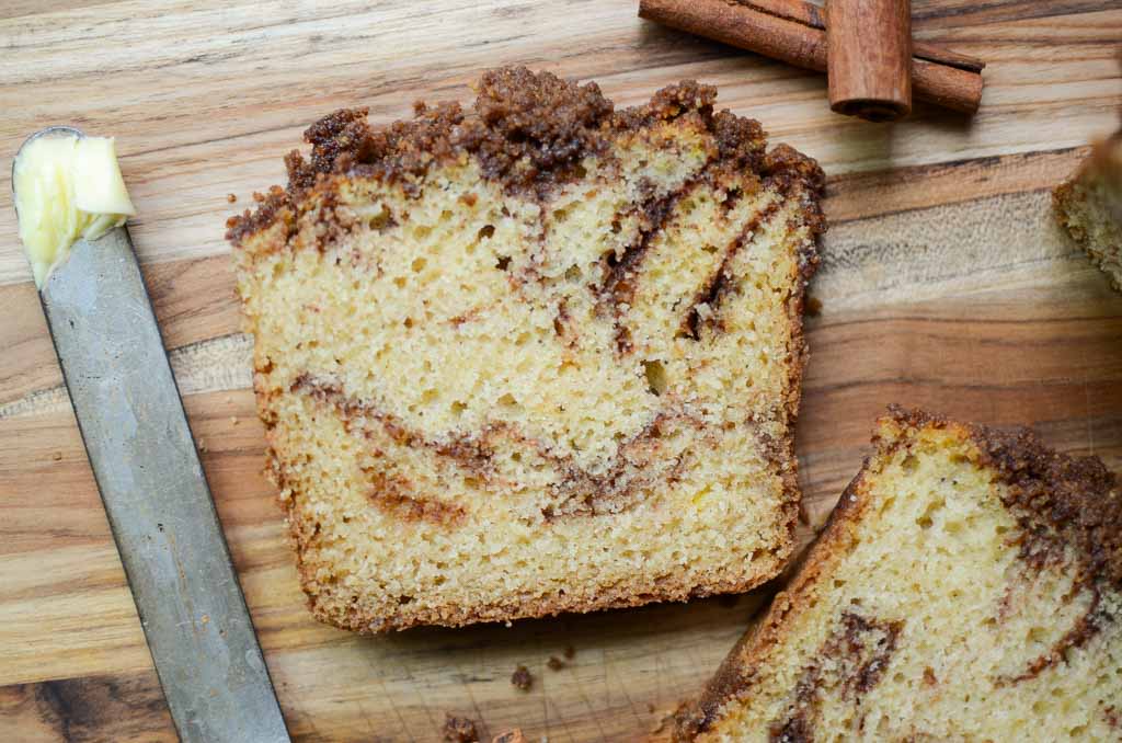 a slice of sourdough cinnamon sugar quick bread on wood cutting board