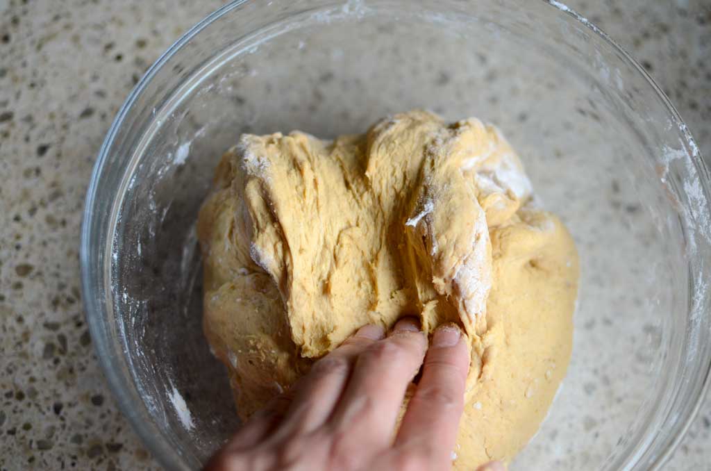 folding the dough over onto itself in a glass bowl 