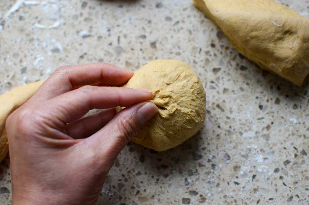 pinching the ends of the dough together to form a ball