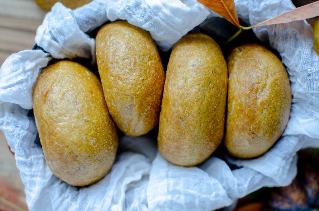 4 sourdough pumpkin bagels in a cloth-lined basket