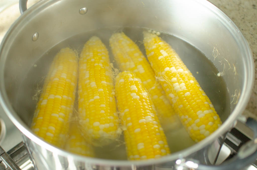  corn ears in a pot of boiling water