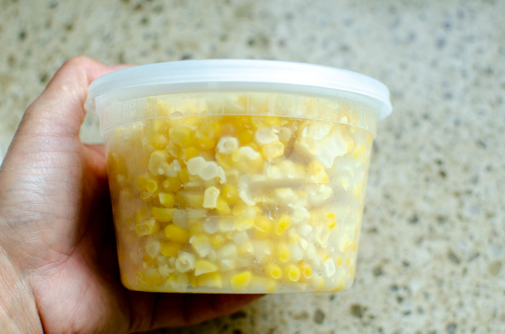 a plastic container filled with cut sweet corn