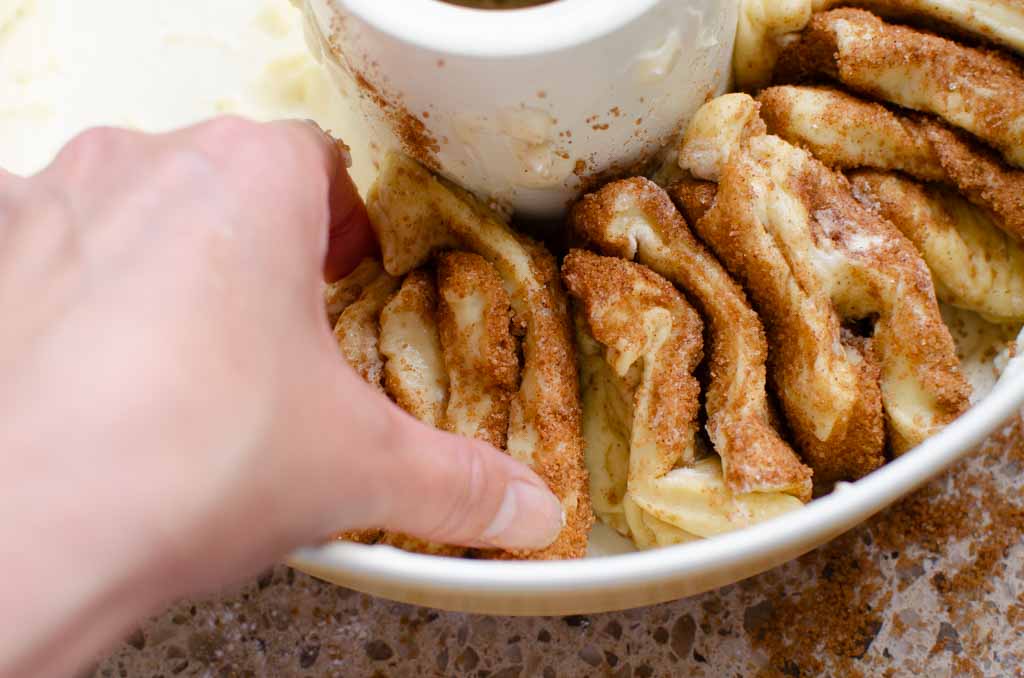 placing the small  bread dough squares into the pan