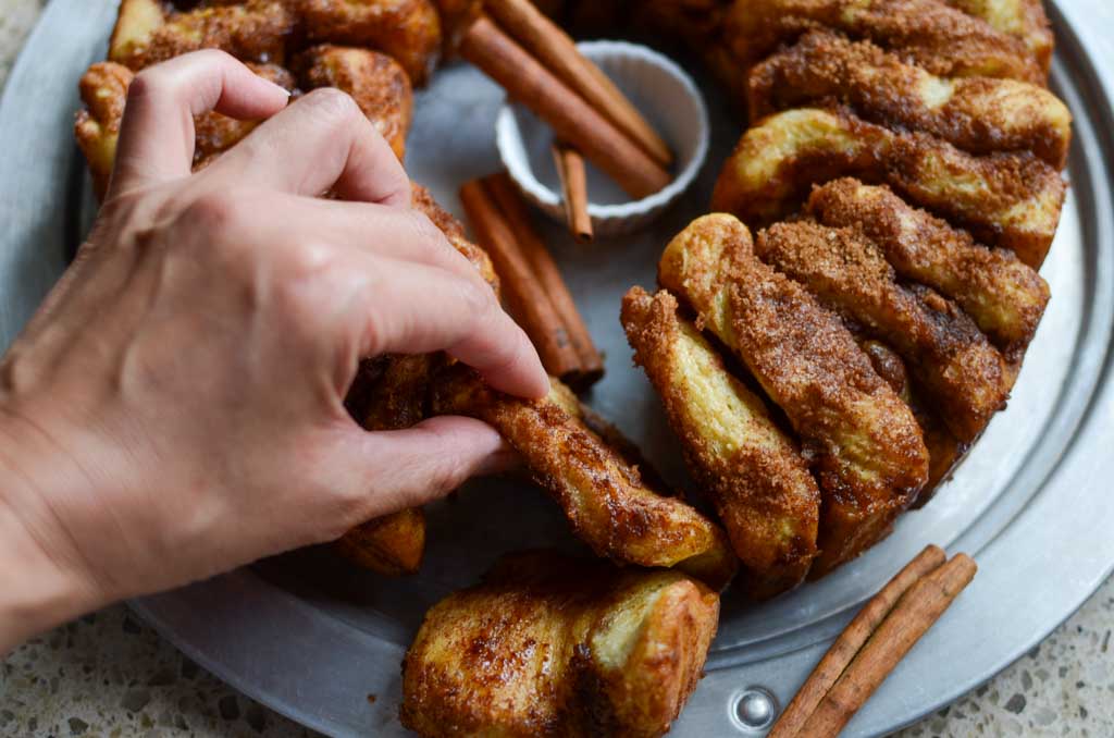 taking a piece of sourdough cinnamon sugar pull apart bread