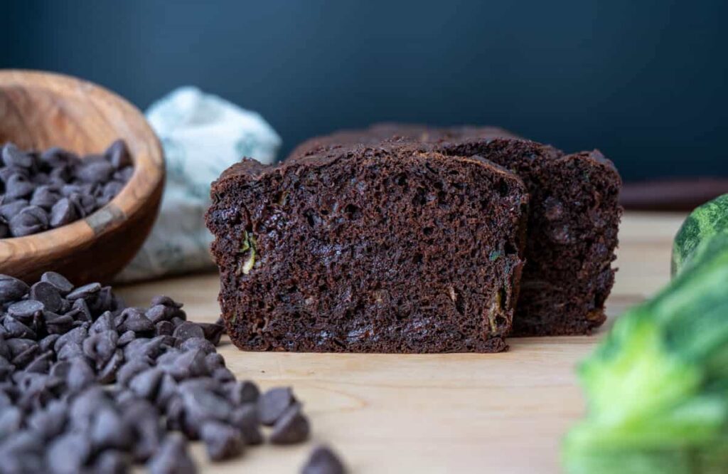 sourdough chocolate zucchini bread with chocolate chips and zucchini next to it