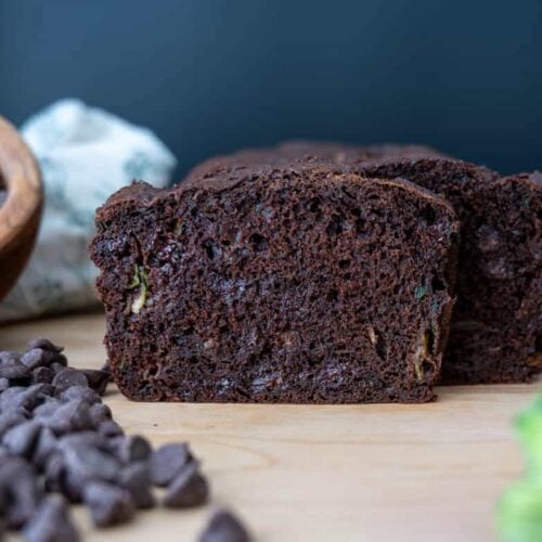 sourdough chocolate zucchini bread with chocolate chips and zucchini next to it