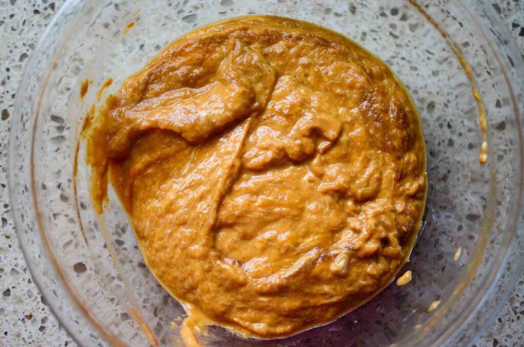 The wet ingredients in a glass bowl for sourdough pumpkin bread