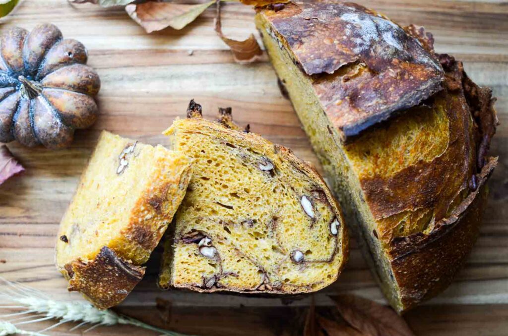 slices of artisan  pumpkin and pecan sourdough bread on cutting board