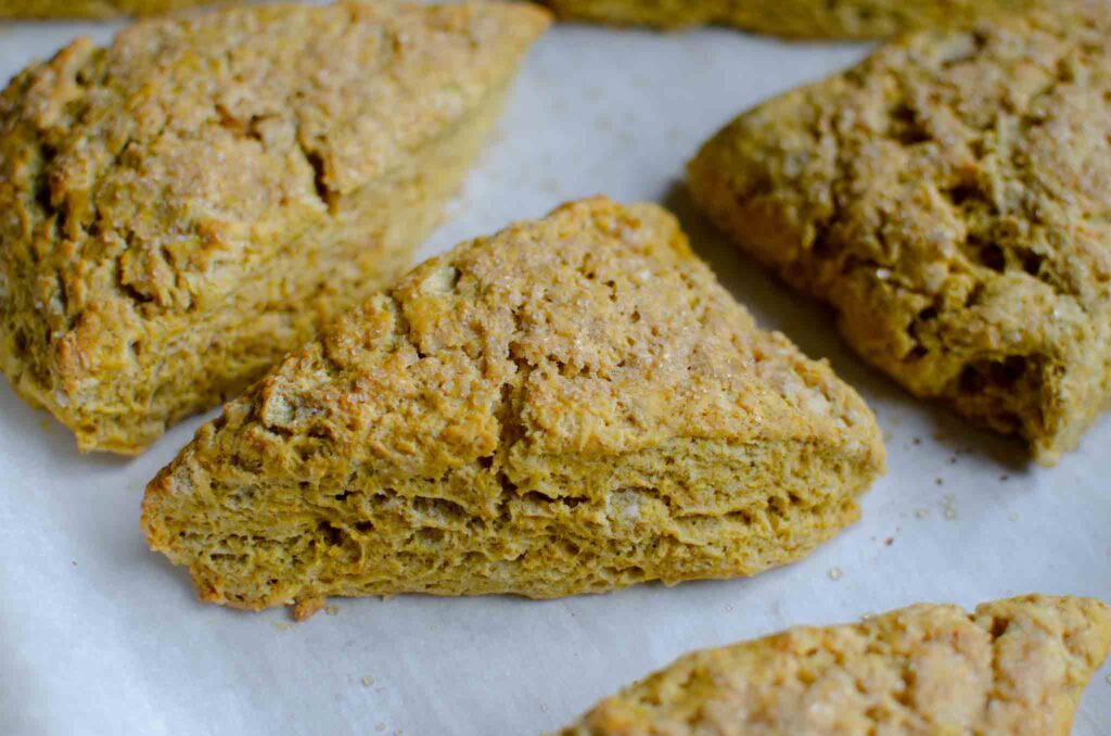 baked sourdough pumpkin scones on a parchment-lined baking sheet