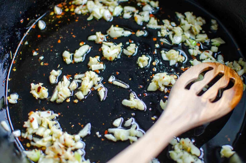 minced garlic and red pepper flakes in oil in pan