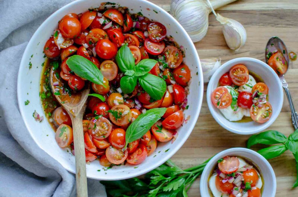 a large bowl and two small bowls of marinated tomatoes